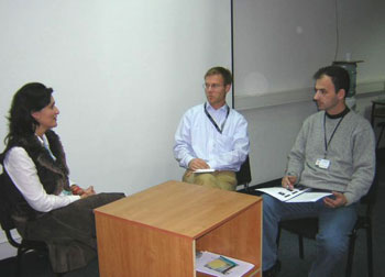 Three participants engage in a role-play simulation for negotiations involving 3rd parties