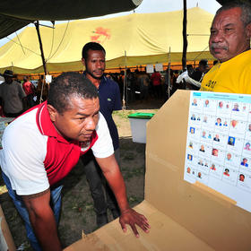 Electoral Commission workers show locals through the mock poll booth setup in Port Moresby, Papua New Guinea, June 2012. (Australia Department of Foreign Affairs and Trade/CC License 2.0)