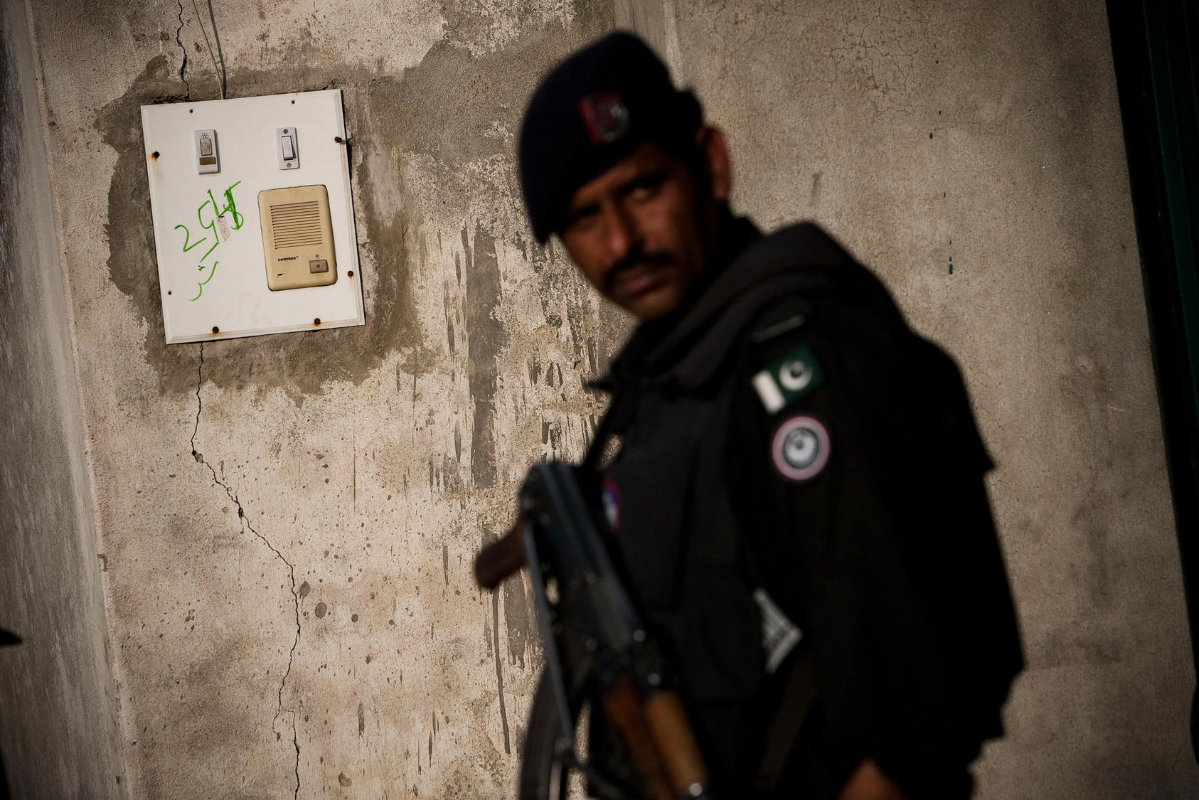 A Pakistani policeman stands next to the intercom at the entrance to the compound where Osama Bin Laden was killed in Abbottabad, Pakistan.
