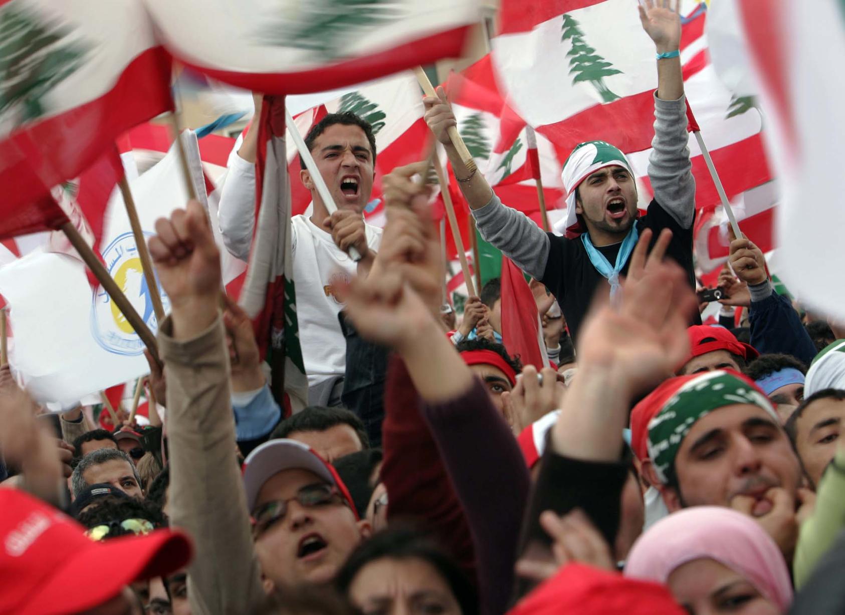 Demonstrators wave the flag of Lebanon during a rally in Beirut. (Shawn Baldwin/The New York Times)