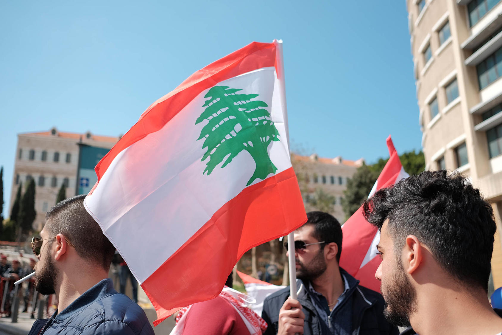 Lebanese protesters with Lebanese flag. (Photo Credit: Jeff Merheb / Shutterstock.com)