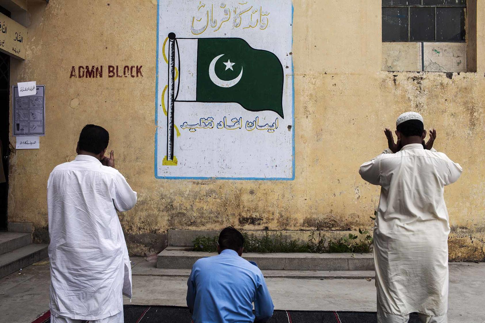 Men pray outside a polling station on Election Day in Islamabad, Pakistan in May 2013. (Diego Ibarra Sanchez/The New York Times)