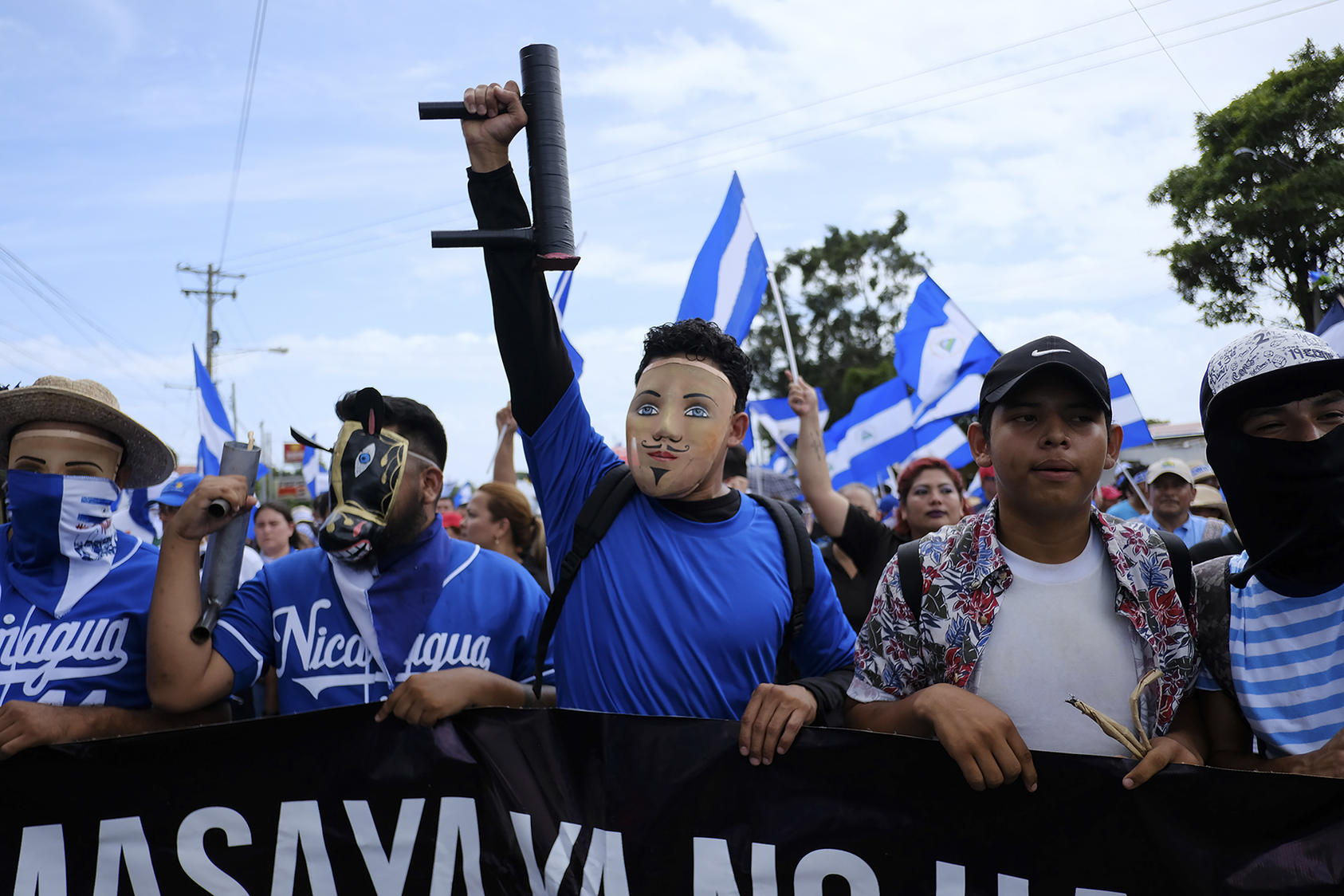 Protesters wearing folkloric masks and carrying crude, homemade mortars march through Managua, Nicaragua, July 12, 2018. (Brent McDonald/The New York Times)