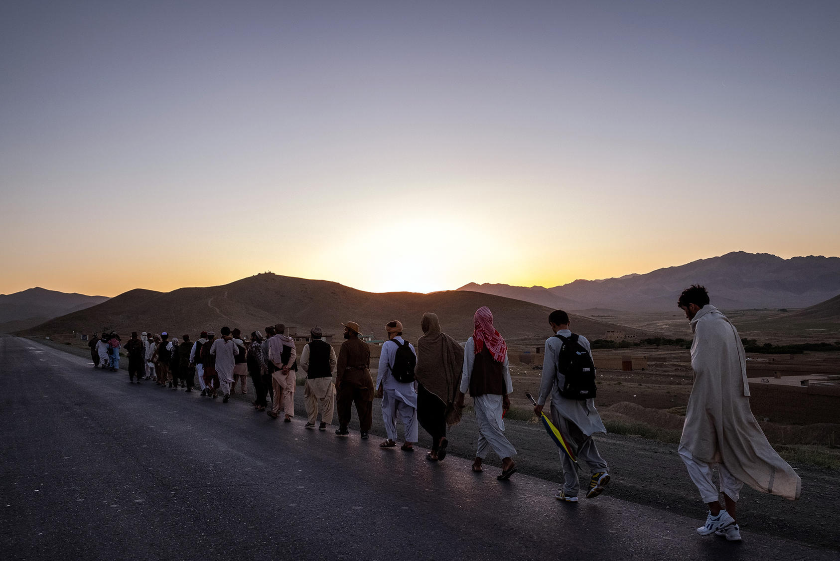Dozens of men march for peace through southern Afghanistan, near Ghazni, on June 12, 2018. Talks between the Americans and the Taliban have many Afghans caught up in the hope of an unprecedented moment. (Jim Huylebroek/The New York Times)