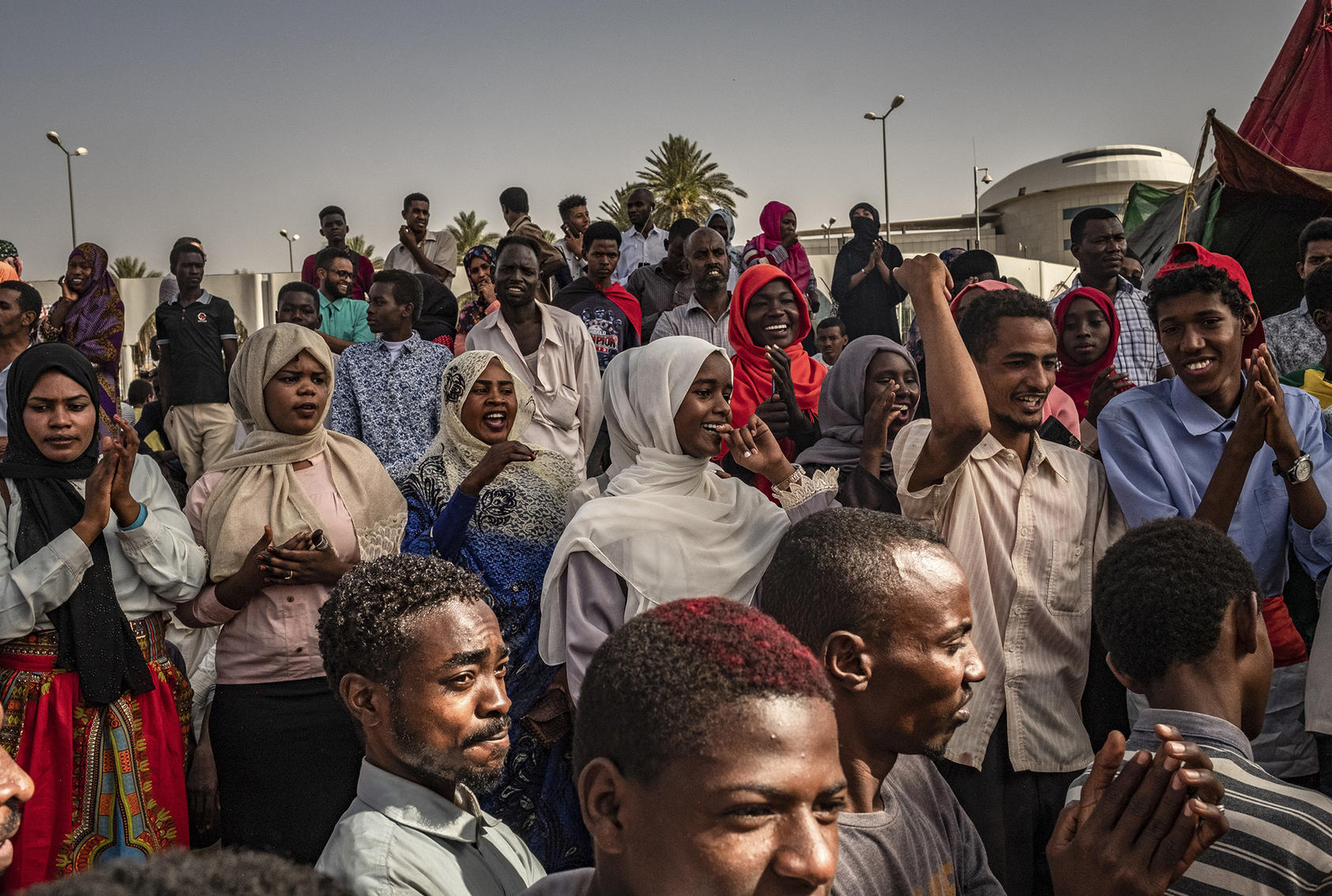 Men and women listen to music, sing and chant during a sit-in at the military headquarters in Khartoum, Sudan, April 27, 2019. (Bryan Denton/The New York Times)