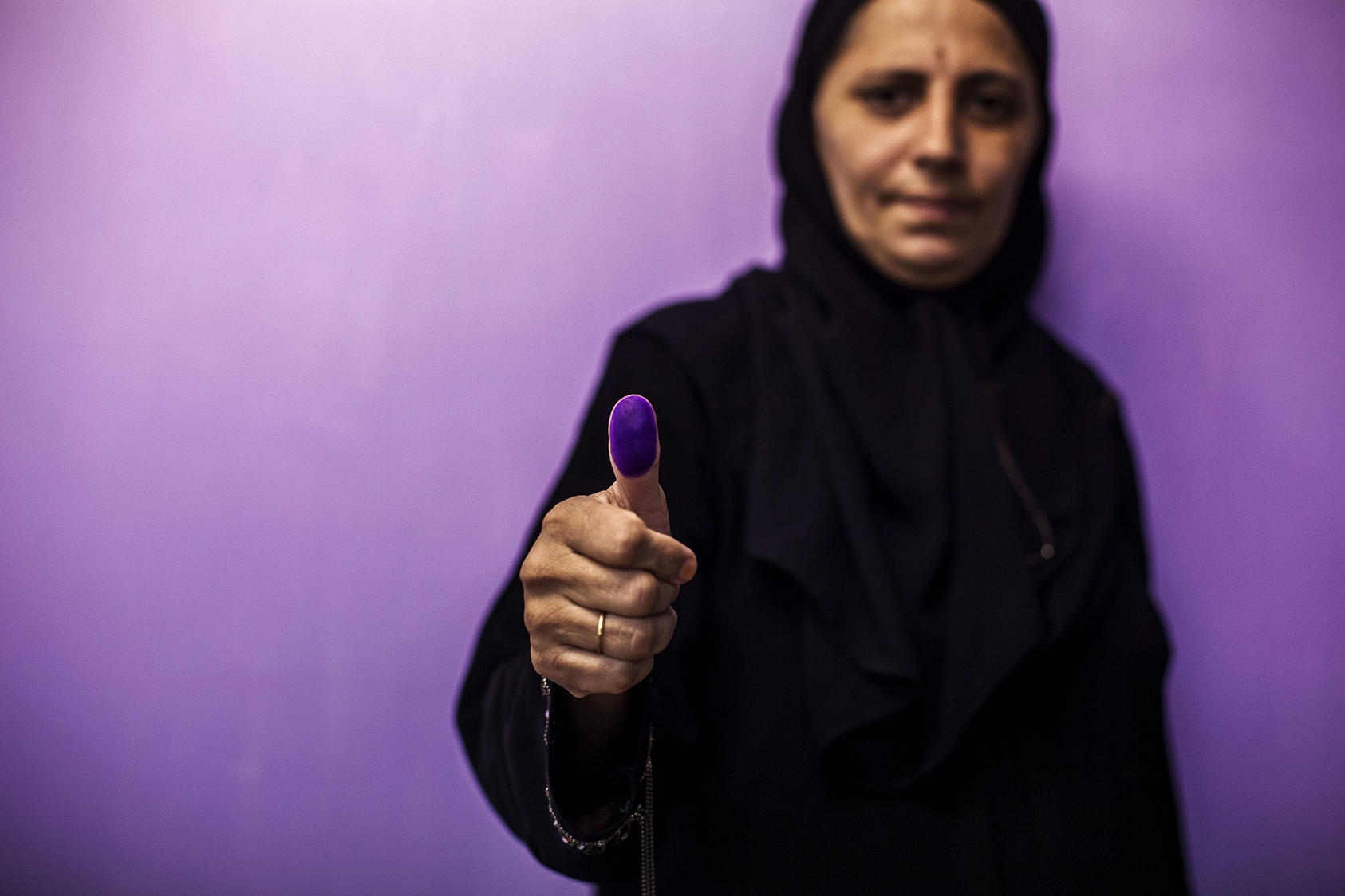 A woman shows her ink-covered thumb after casting her vote at a polling station during a repeat of the parliamentary election in Karachi, Pakistan, May 19, 2013. (Diego Ibarra Sanchez/The New York Times)