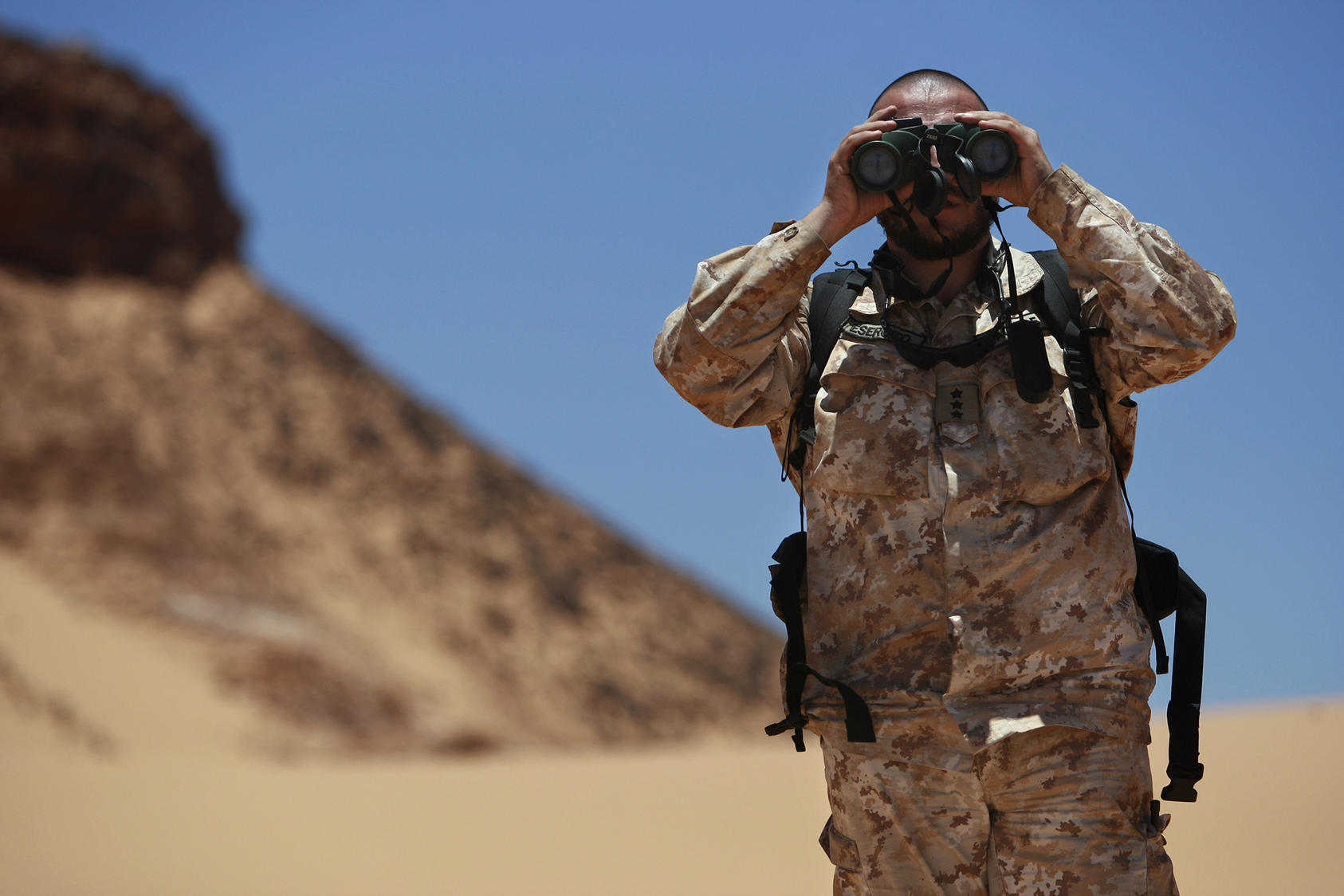 Antonio Achille, working with the Military Liaison Office of the U.N. Mission for the Referendum in Western Sahara, looks through binoculars during a cease-fire monitoring patrol in Oum Dreyga, Western Sahara. (United Nations Photo)