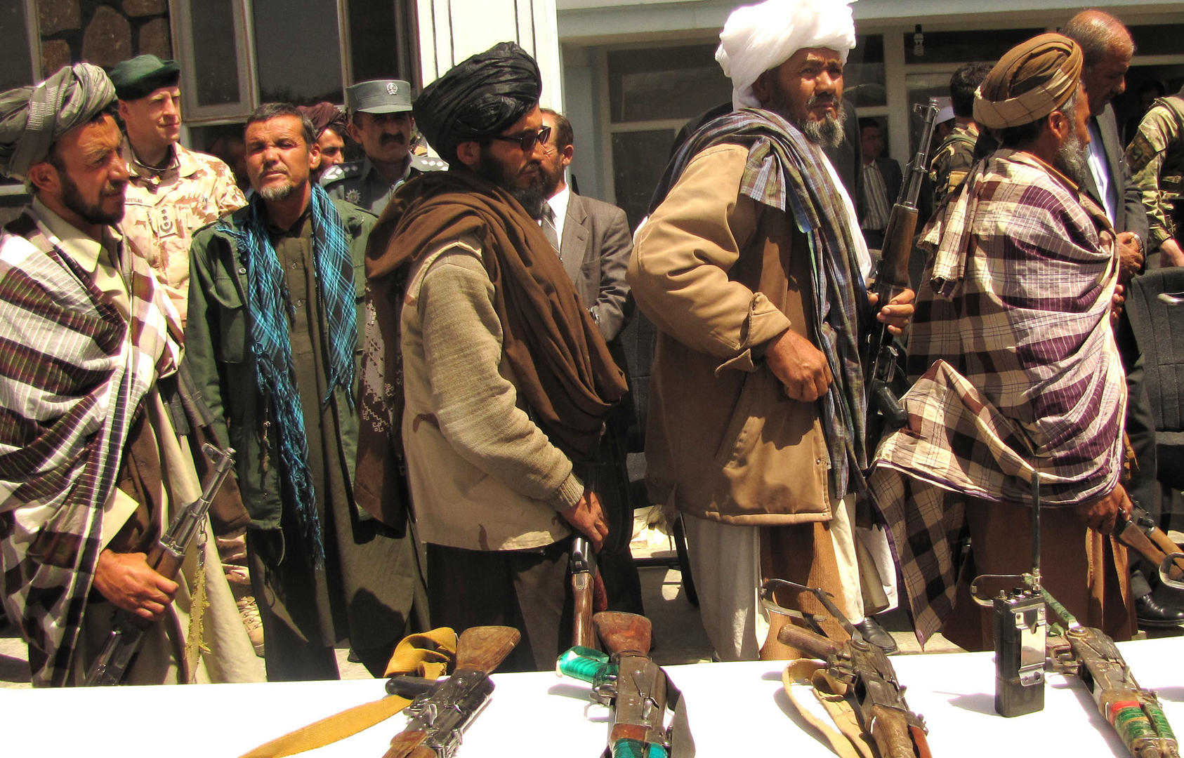 Former Taliban fighters line up to handover their rifles to the Afghan Government during a reintegration ceremony, May 2012. (Department of Defense/Lt. j. g. Joe Painter)