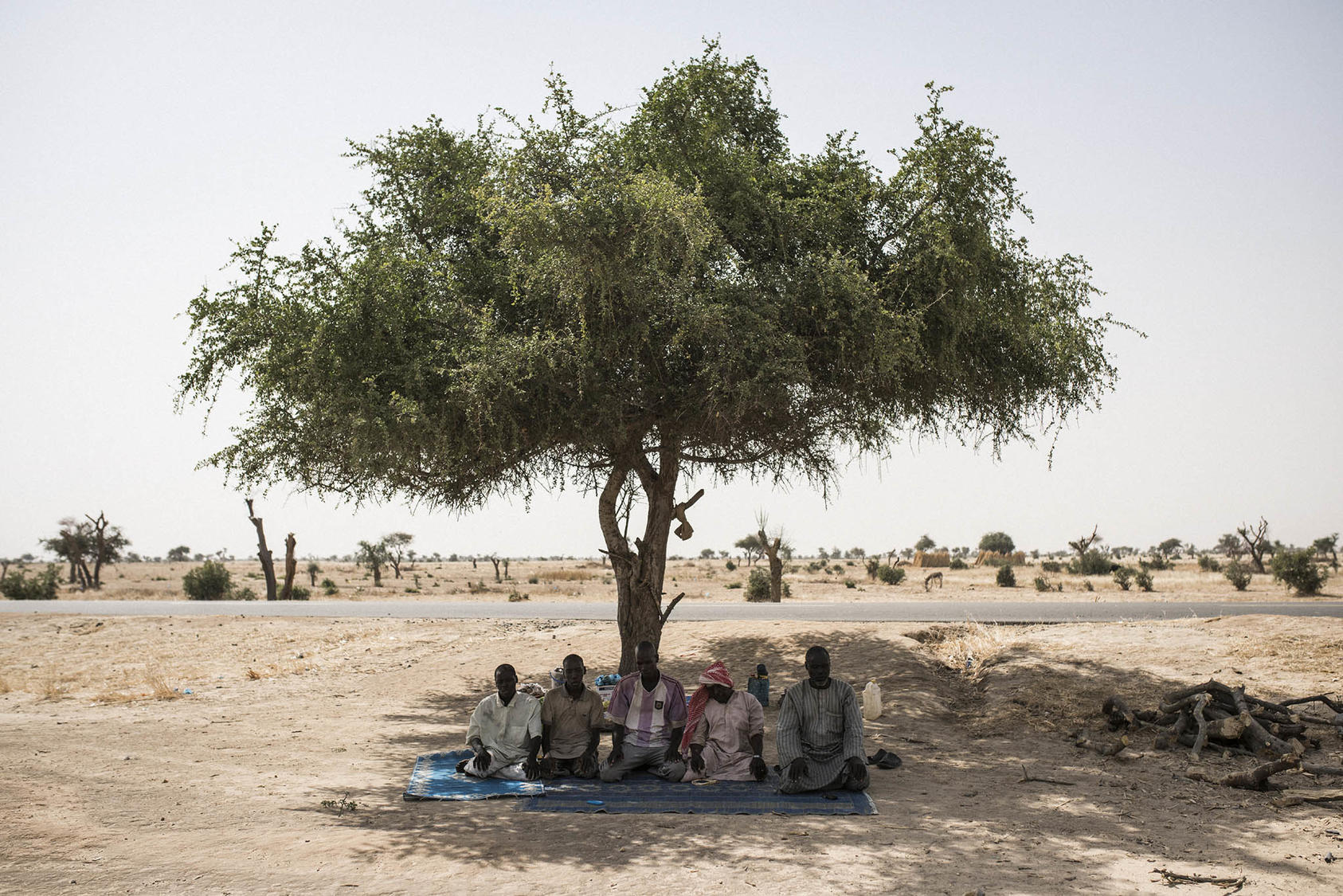 Nigerian men who fled their country’s Boko Haram conflict seek shade to pray in neighboring Niger. Violence involving Boko Haram has uprooted most of the quarter-million Nigerians who have taken refuge in nearby states. (Adam Ferguson/The New York Times)