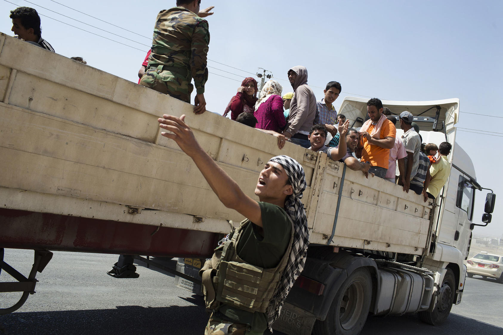 Members of Iraq’s Yazidi minority who fled their homes in Sinjar are transported by truck near Bardarash, in Iraq’s Kurdish north, Aug. 7, 2014. (Adam Ferguson/The New York Times)