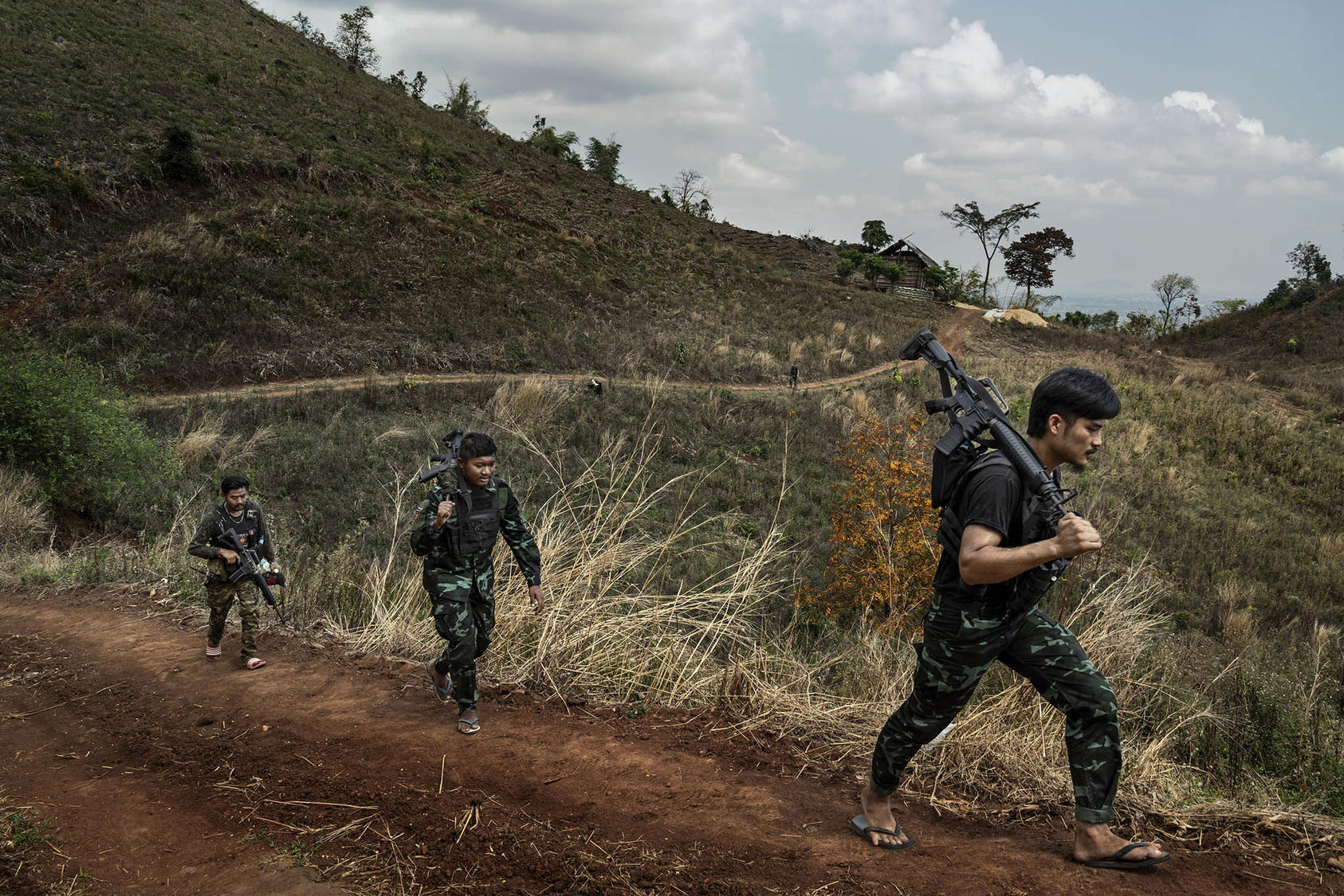 Rebel militia fighters of the People’s Defense Forces patrol a front line area near government military positions in the Kayin State of Myanmar. March 9, 2022. (Adam Dean/The New York Times)