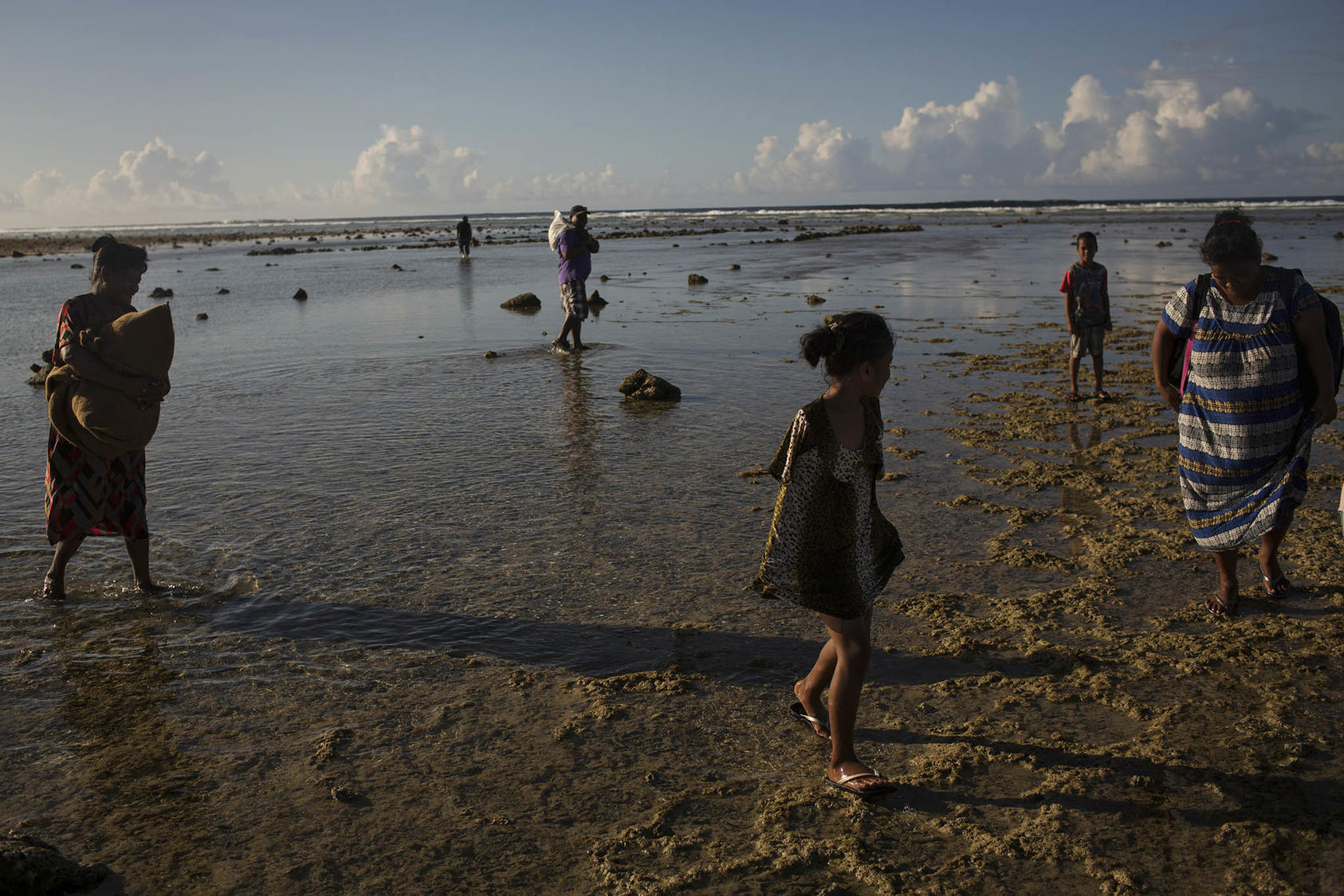 Residents cross between islands during a rising tide on Majuro, Marshall Islands, on Nov. 4, 2015. Majuro is home to former residents of Bikini Atoll who were relocated in the 1940s. (Josh Haner/The New York Times)