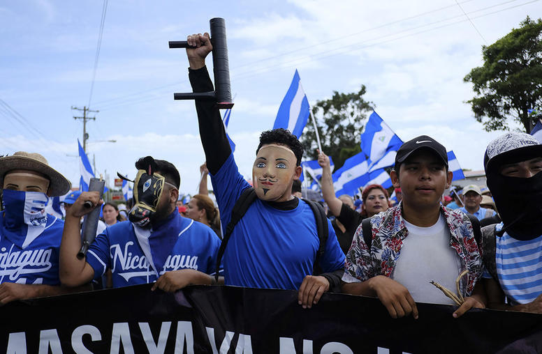 Protesters wearing folkloric masks and carrying crude, homemade mortars march through Managua, Nicaragua, July 12, 2018