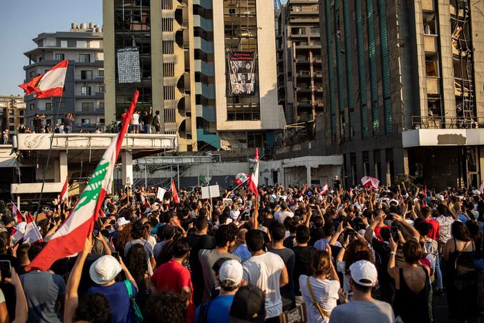 Demonstrators look on at an unfurled banner in Beirut, Lebanon on Wednesday, Aug. 4, 2021. (Diego Ibarra Sanchez/The New York Times)