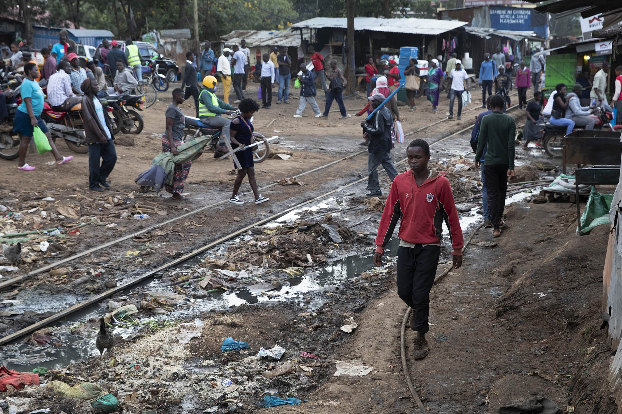 Kenyans walk in Kibera, Africa’s largest slum, in Nairobi. Kenya’s deep inequality between rich and poor, plus high unemployment in a heavily young population, are roots of this month’s Kenyan protests and violence. (Tyler Hicks/The New York Times)