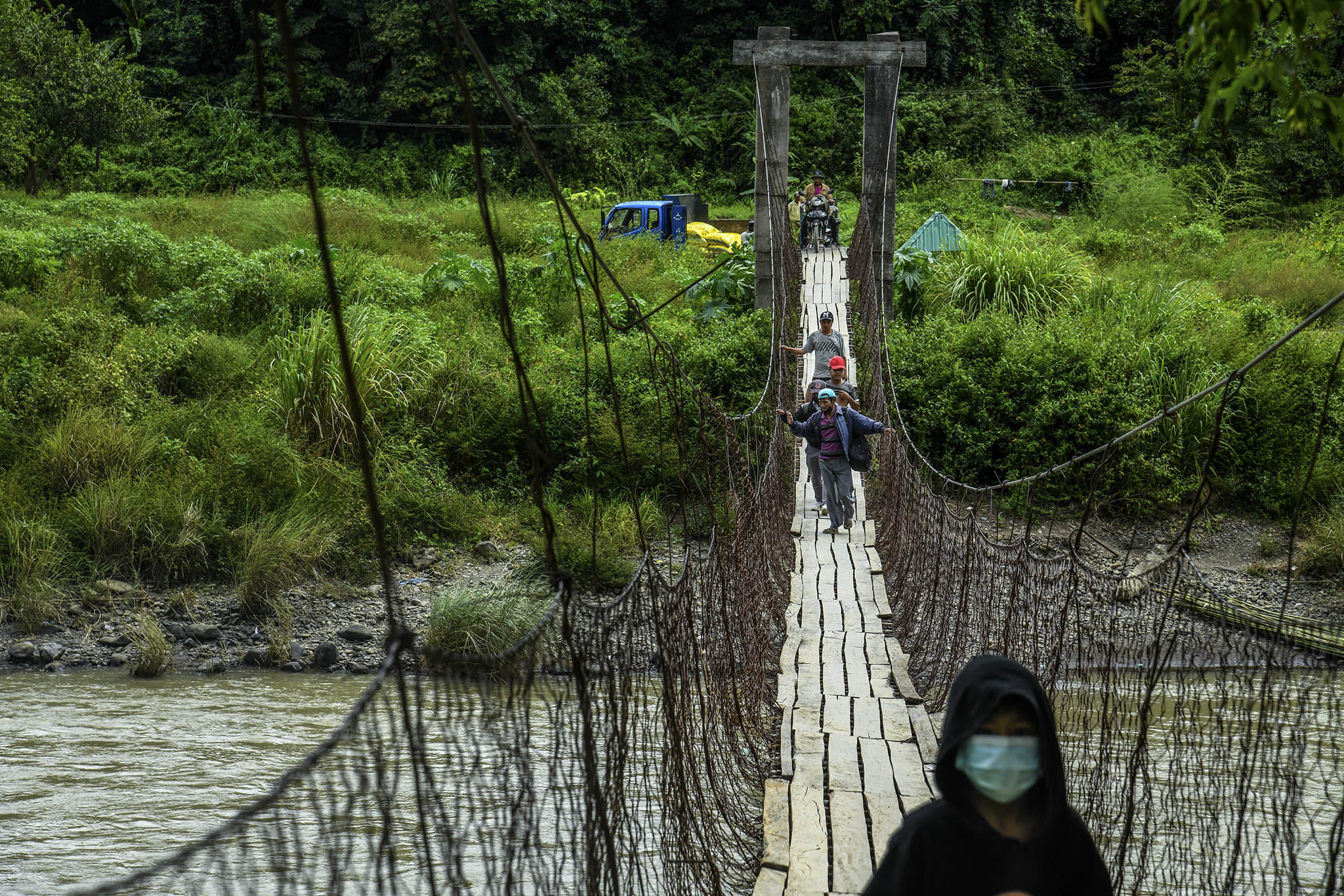 Refugees cross a suspension bridge from Myanmar into India on Oct. 16, 2021. The Myanmar military’s scorched earth warfare is creating chaos on the India border. (Atul Loke/The New York Times)
