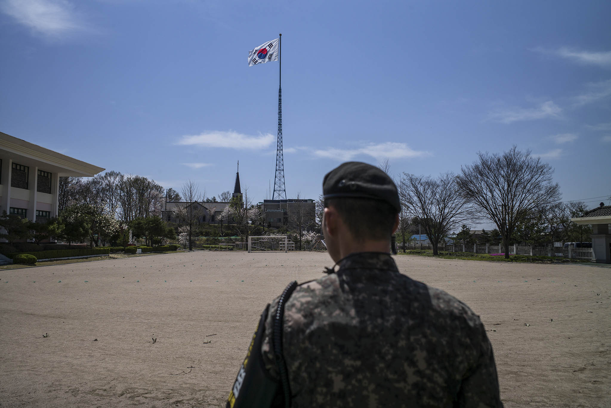 A soldier stands at a school playground in Taesung, also known as Freedom Village, located in the Demilitarized Zone in South Korea, April 19, 2017. (Lam Yik Fei/The New York Times)