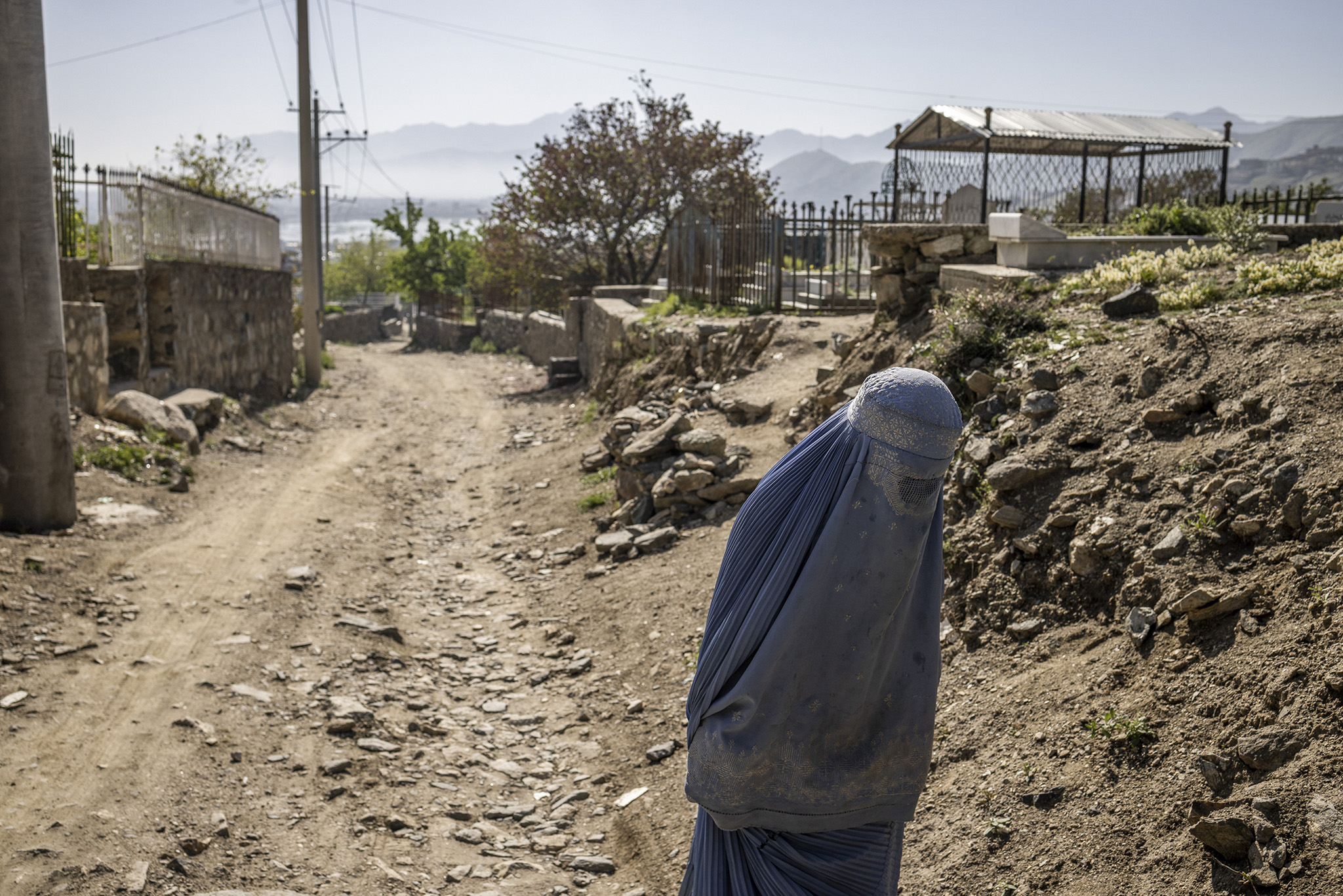 A woman walks on a road in Kabul, Afghanistan, on April 20, 2023. Three years into its rule, the Taliban has codified its harsh Islamic decrees into law that now includes a ban on women’s voices in public. (Jim Huylebroek/The New York Times)