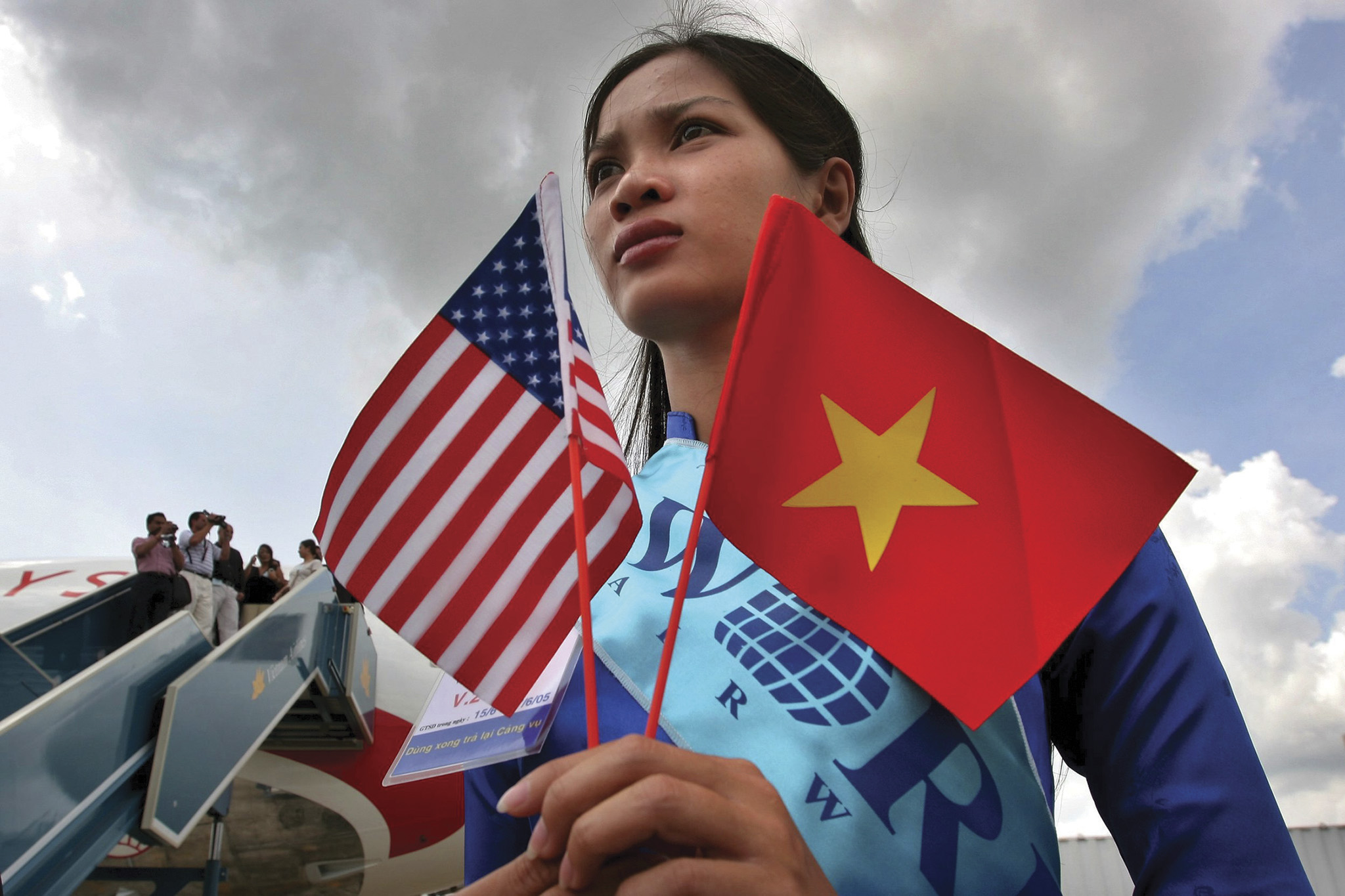 A woman greets a flight marking the 30th anniversary of Operation Babylift in Ho Chi Minh City on June 15, 2005. The flight carried 20 Vietnamese Americans who were among the 2,600 infants and children the operation took from Vietnam to the United States in April 1975. (Photo by Julian Abram Wainwright/EPA/Shutterstock)