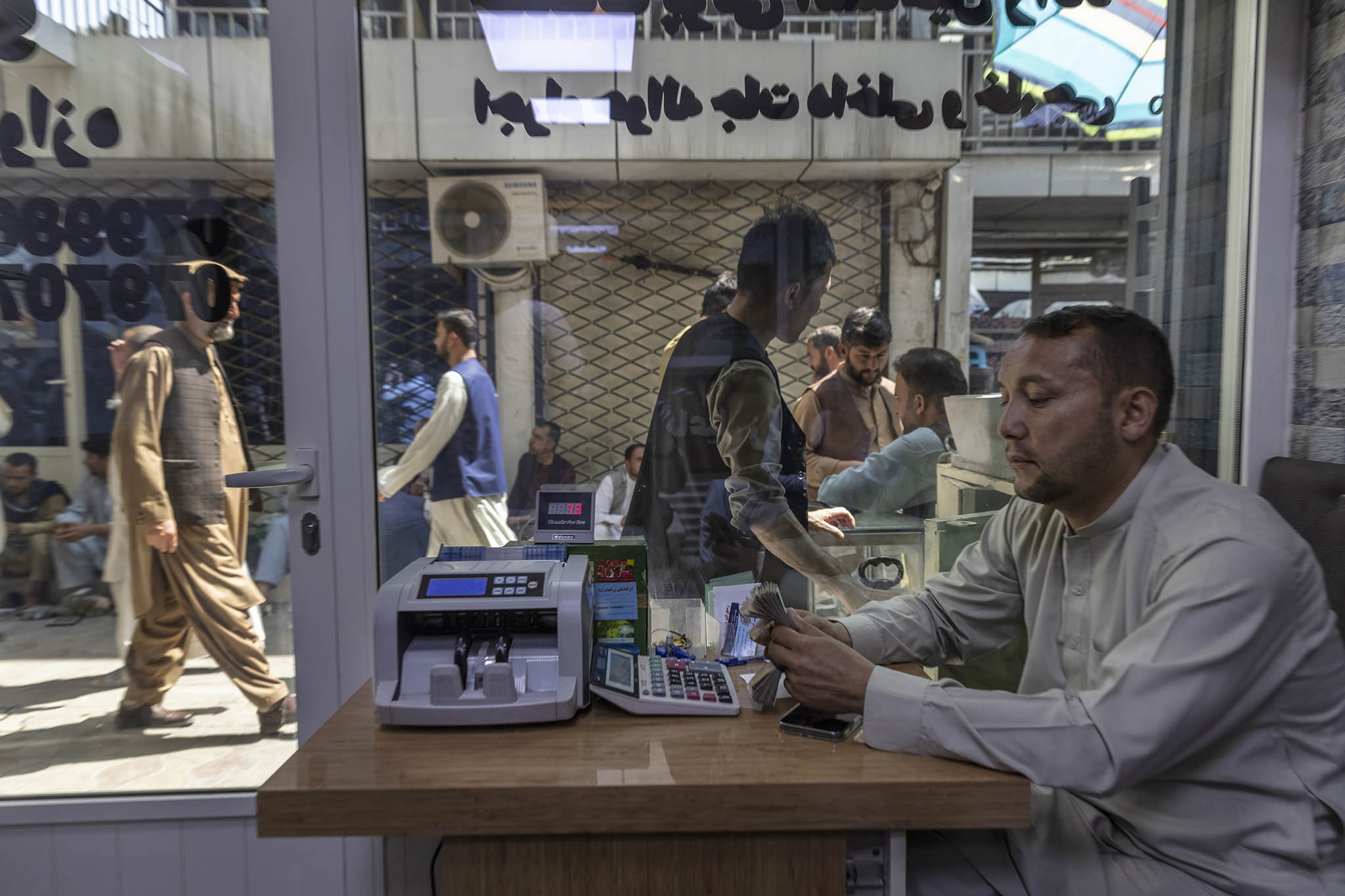 Traders do business at the Sarai Shahzada currency exchange in Kabul, Afghanistan. September 4, 2021. (Victor J. Blue/The New York Times)