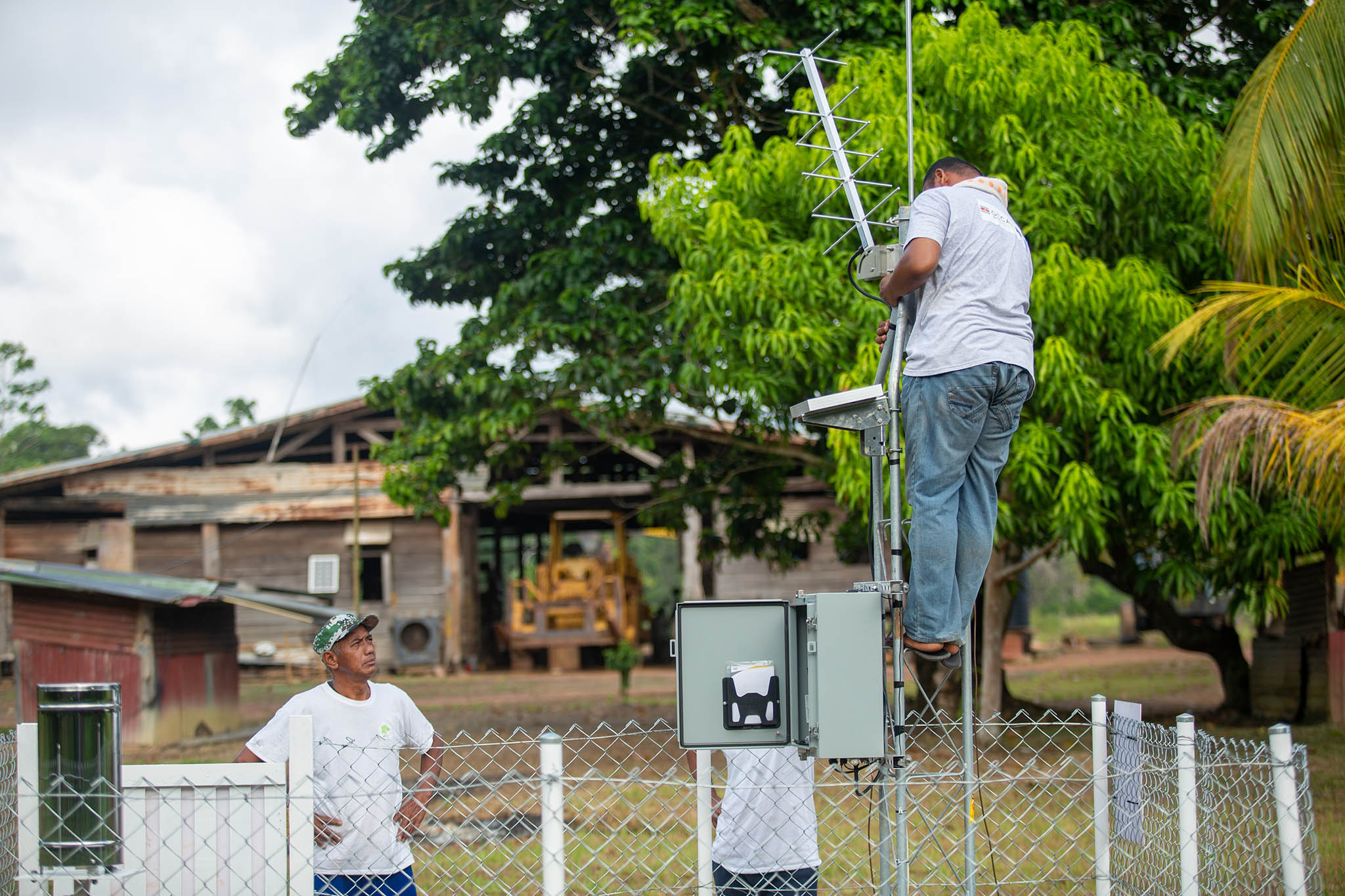 Meteorological Service Suriname installs an antenna for the automatic rain station in the Kabo-Sipaliwini district. November 2023. (Harvey Lisse / UNDP Suriname)