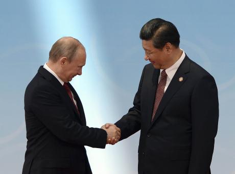 Russian President Vladimir Putin shakes hands with Chinese President Xi Jinping before a summit in Shanghai, May 21, 2014. (Mark Ralston/Pool via The New York Times)