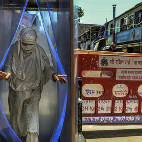 A woman passes through a sanitizing tunnel in Mumbai. April 25, 2020. (Atul Loke/The New York Times)