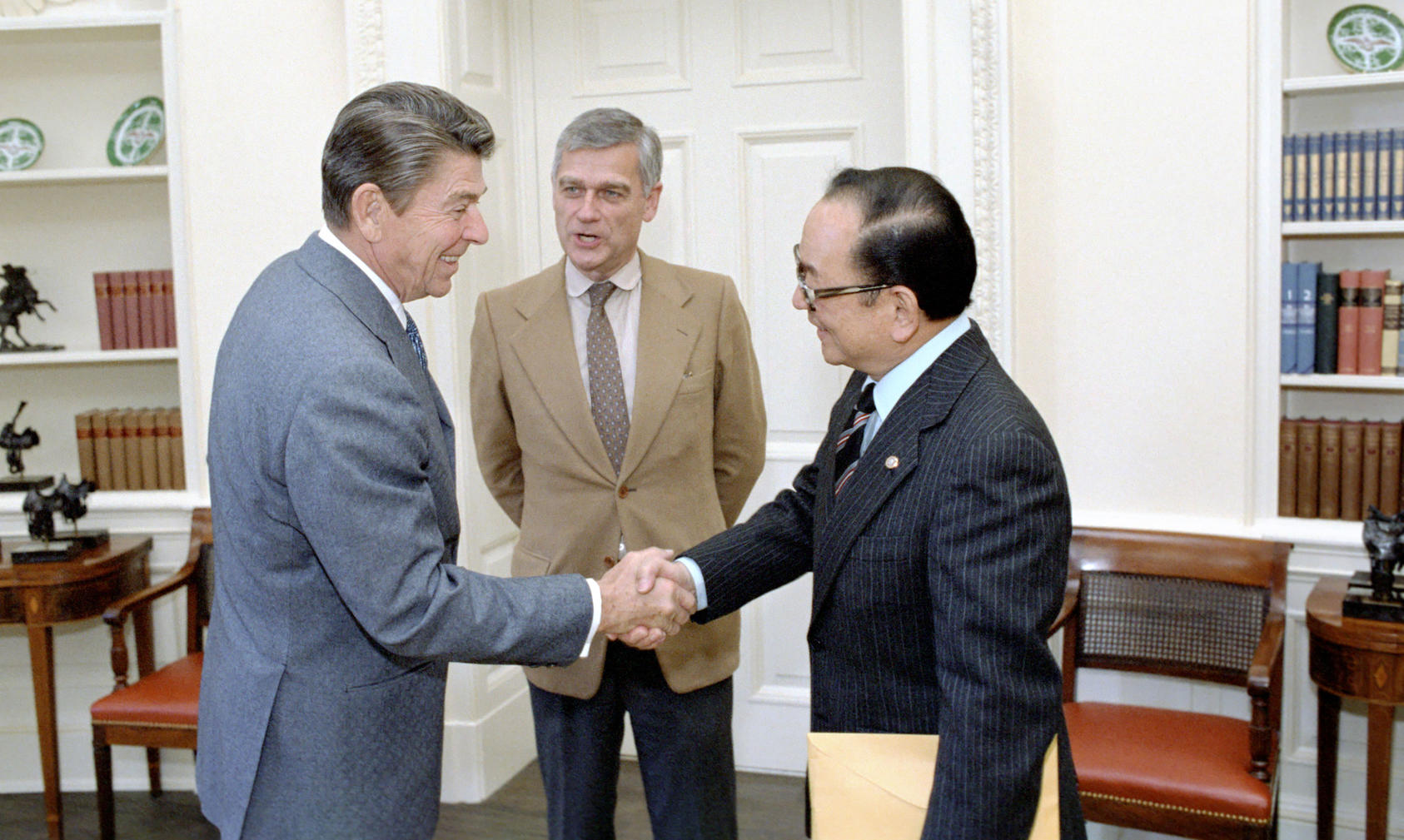 As senators, former World War II lieutenants Spark Matsunaga of Hawaii, right, and Mark Hatfield of Oregon, center, join President Ronald Reagan in 1984 to formally establish the U.S. Institute of Peace. (The White House)