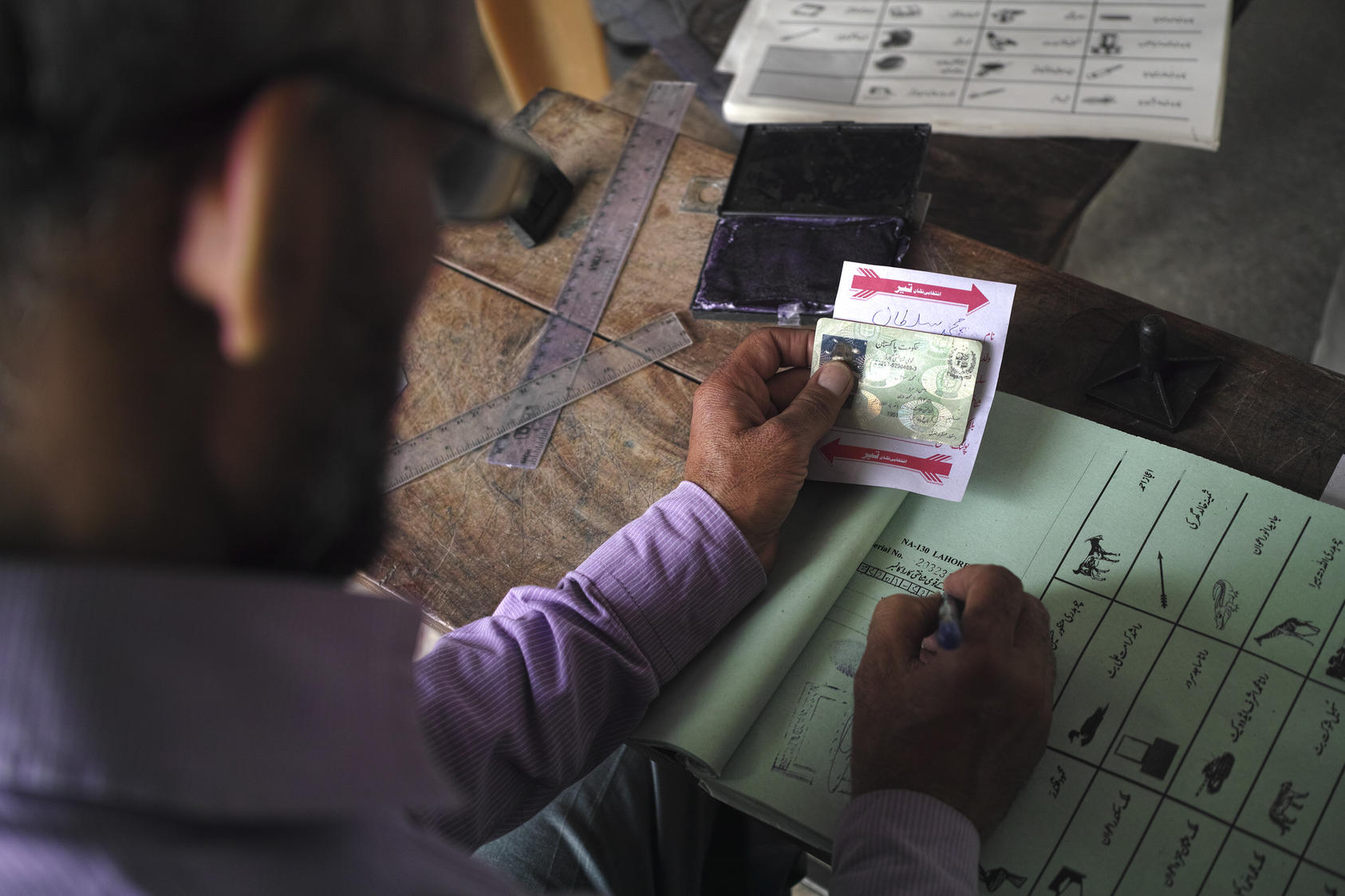 : Identification is checked at a polling station in Wagah, Pakistan (Tyler Hicks/The New York Times)