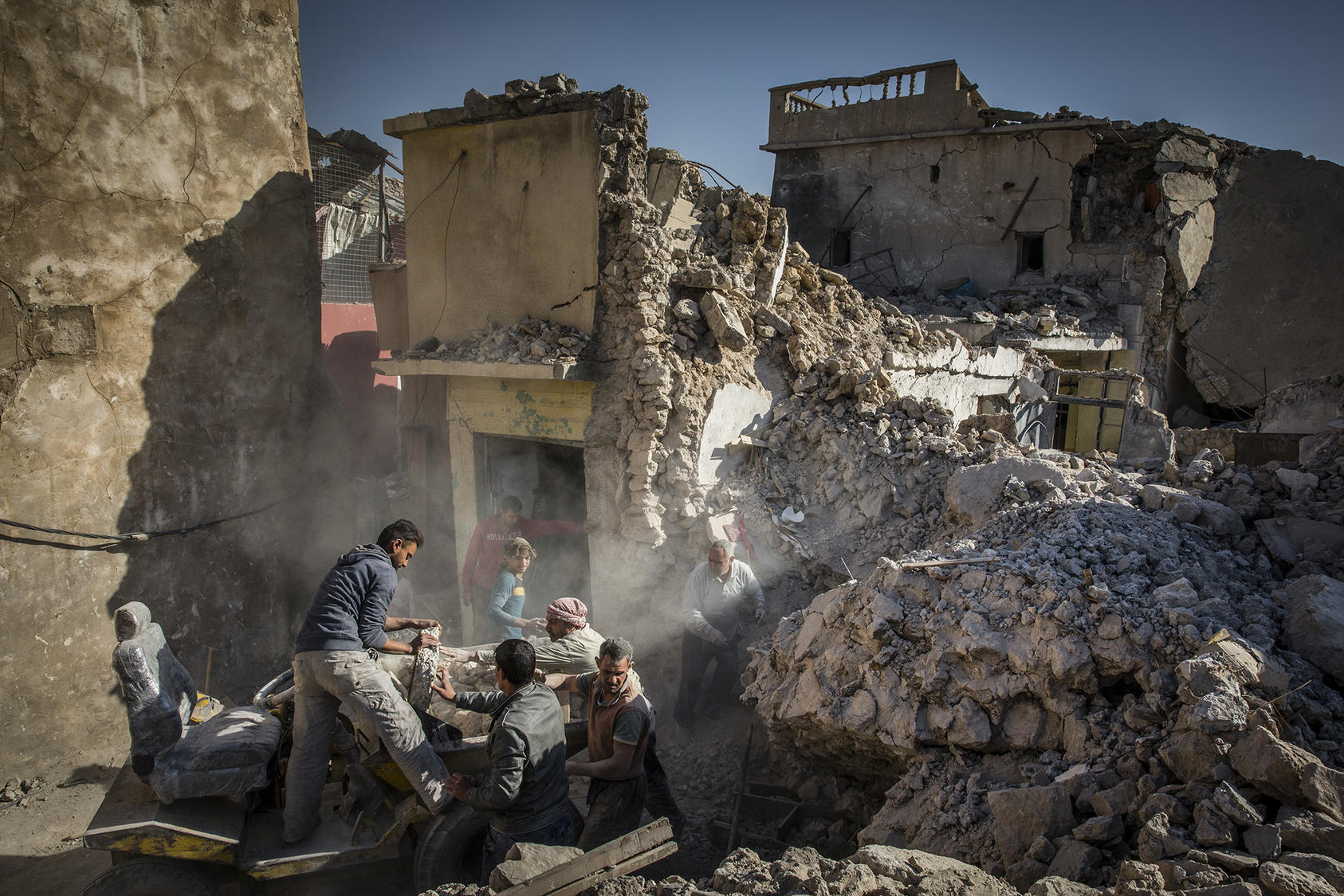 A family works to rebuild a home that was destroyed in the fight to defeat the Islamic State group in the Old City of Mosul, Iraq, Dec. 4, 2017.