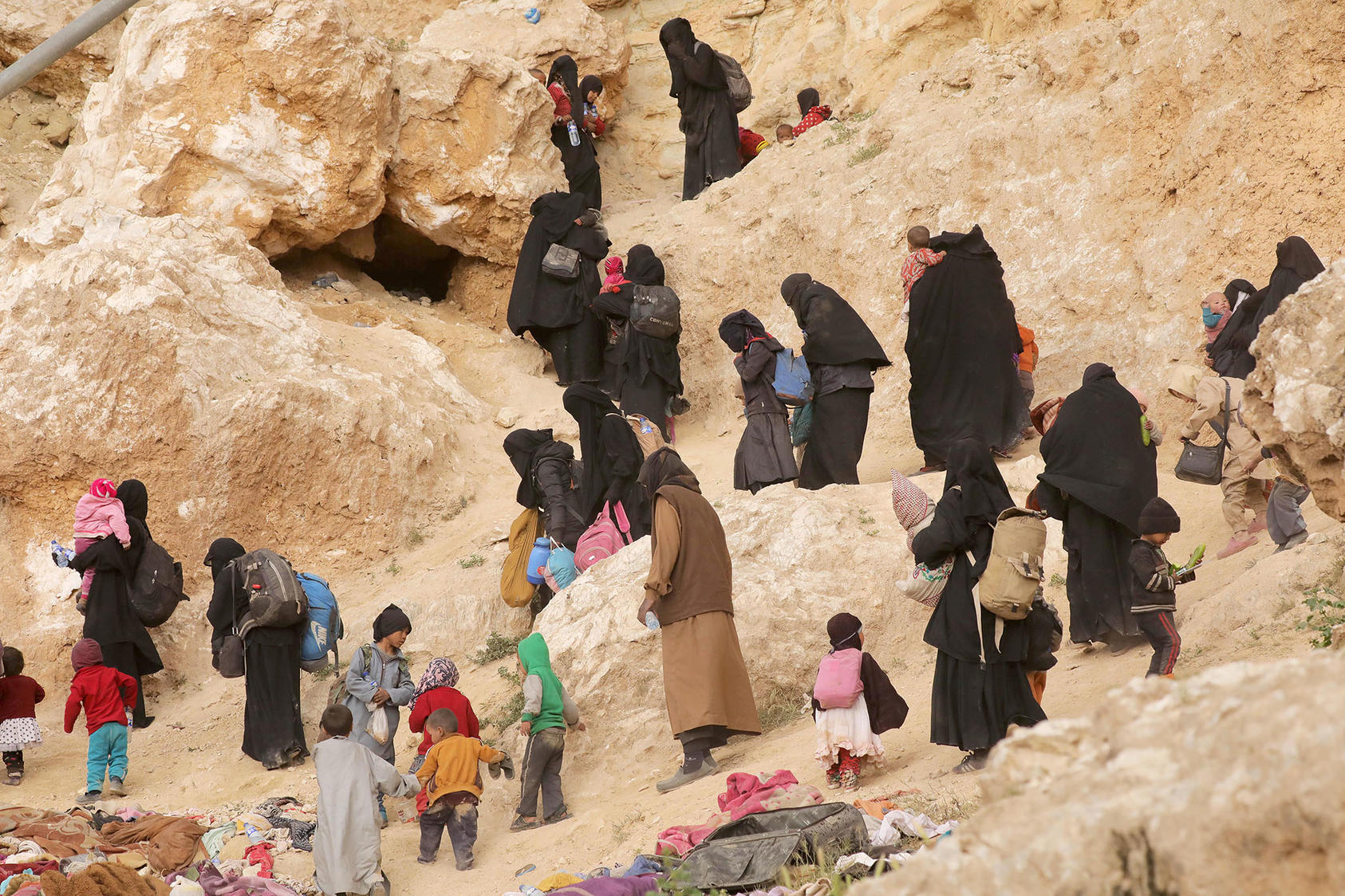 Families of ISIS militants walk near the village of Baghouz, Syria, after the group surrendered to Syrian Democratic Forces in March 2019. (Issam Abdallah/Reuters)