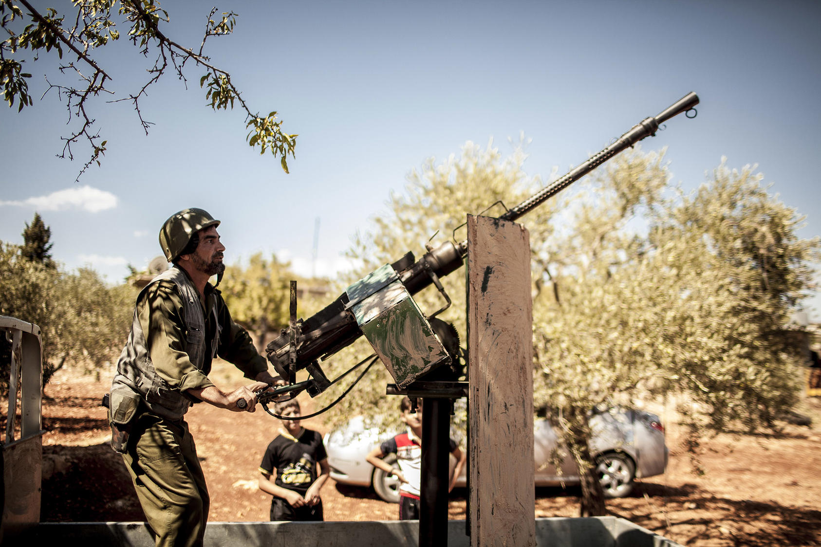 Hajj Abu Omar mounts an anti-aircraft gun in Idlib, Syria, Sept. 21, 2012. (Bryan Denton/The New York Times)