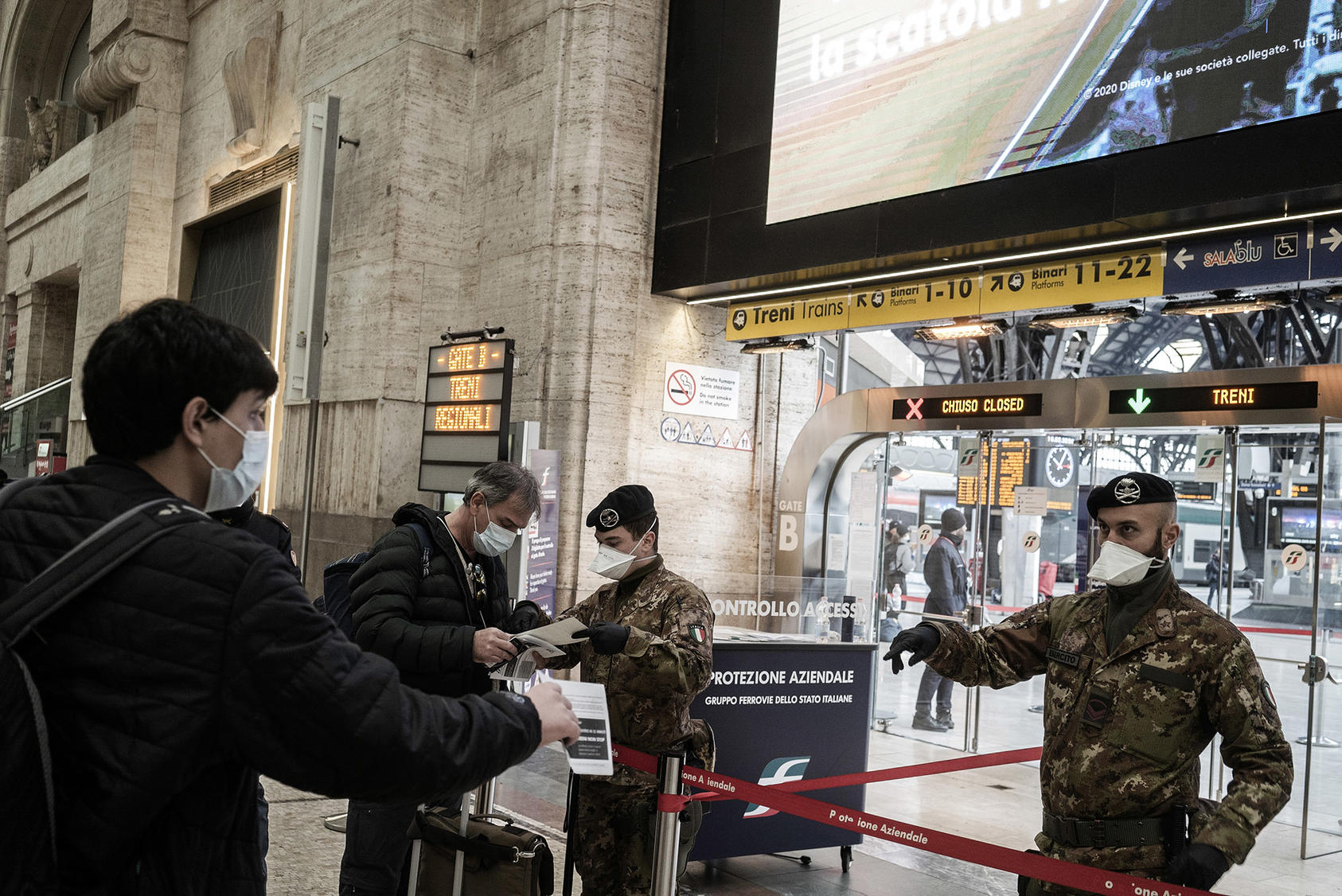 Security forces check passengers at the train station in Milan, March 10, 2020. (Alessandro Grassani/The New York Times)