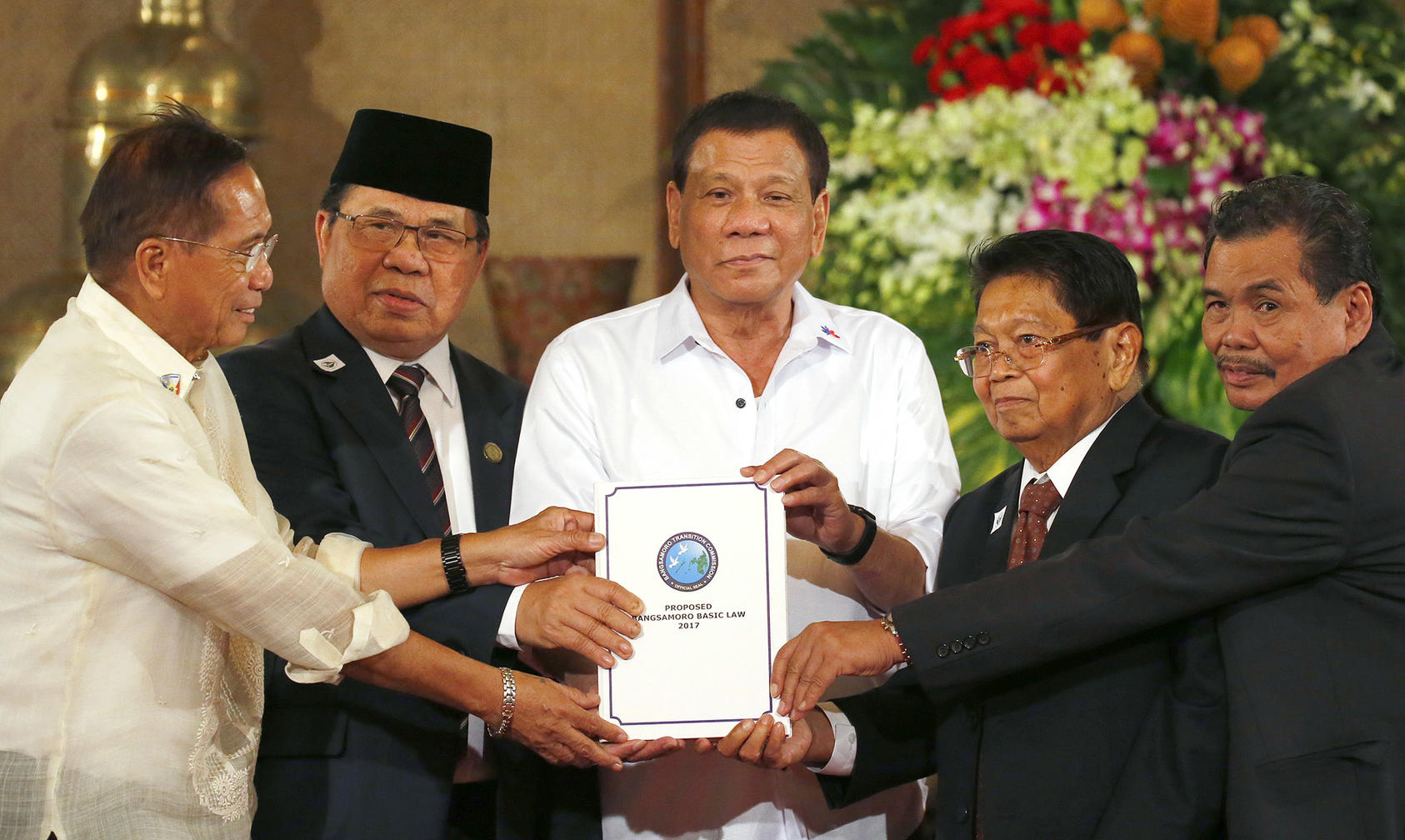 Philippine President Rodrigo Duterte, center, holds the draft of the Bangsamoro Basic Law during a ceremony at Malacañang Palace on July 17, 2017. (Bullit Marquez/AP)