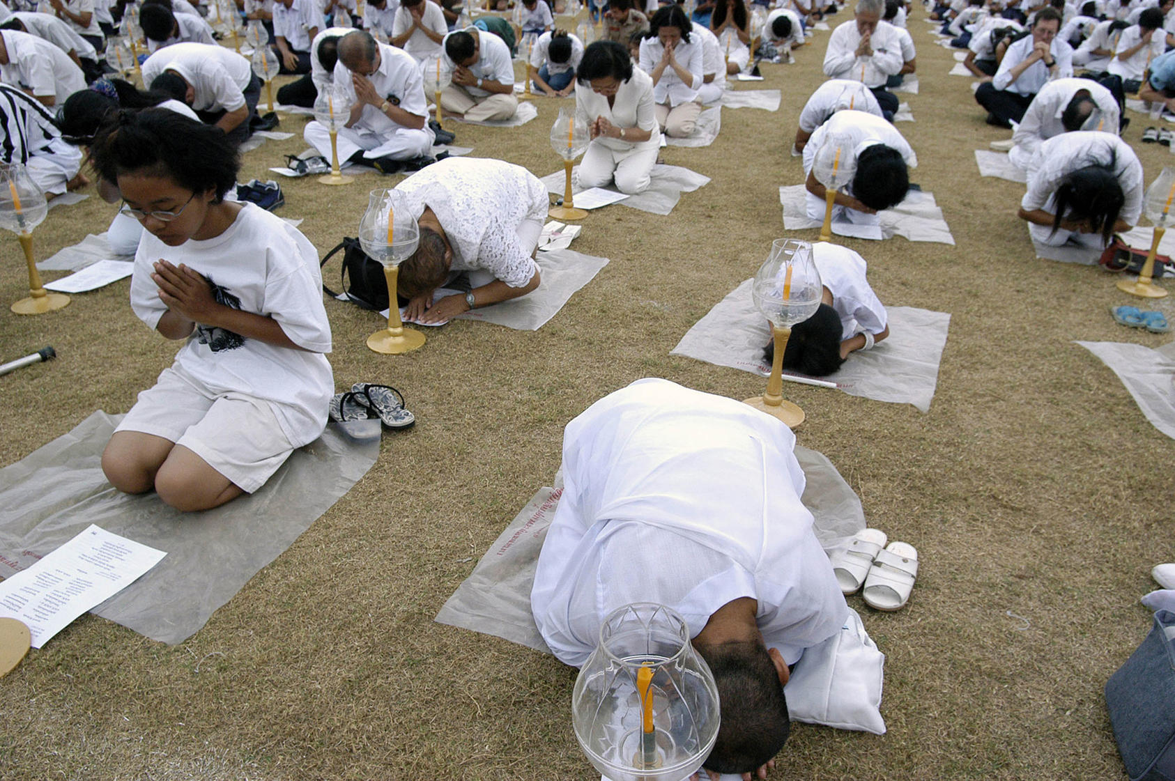 Thousands of Thais, Muslim and Buddhist, pray together for those killed in the 2004 Indian Ocean tsunami. Religious communities increasingly are active against climate-related risks. (Jean Chung/The New York Times