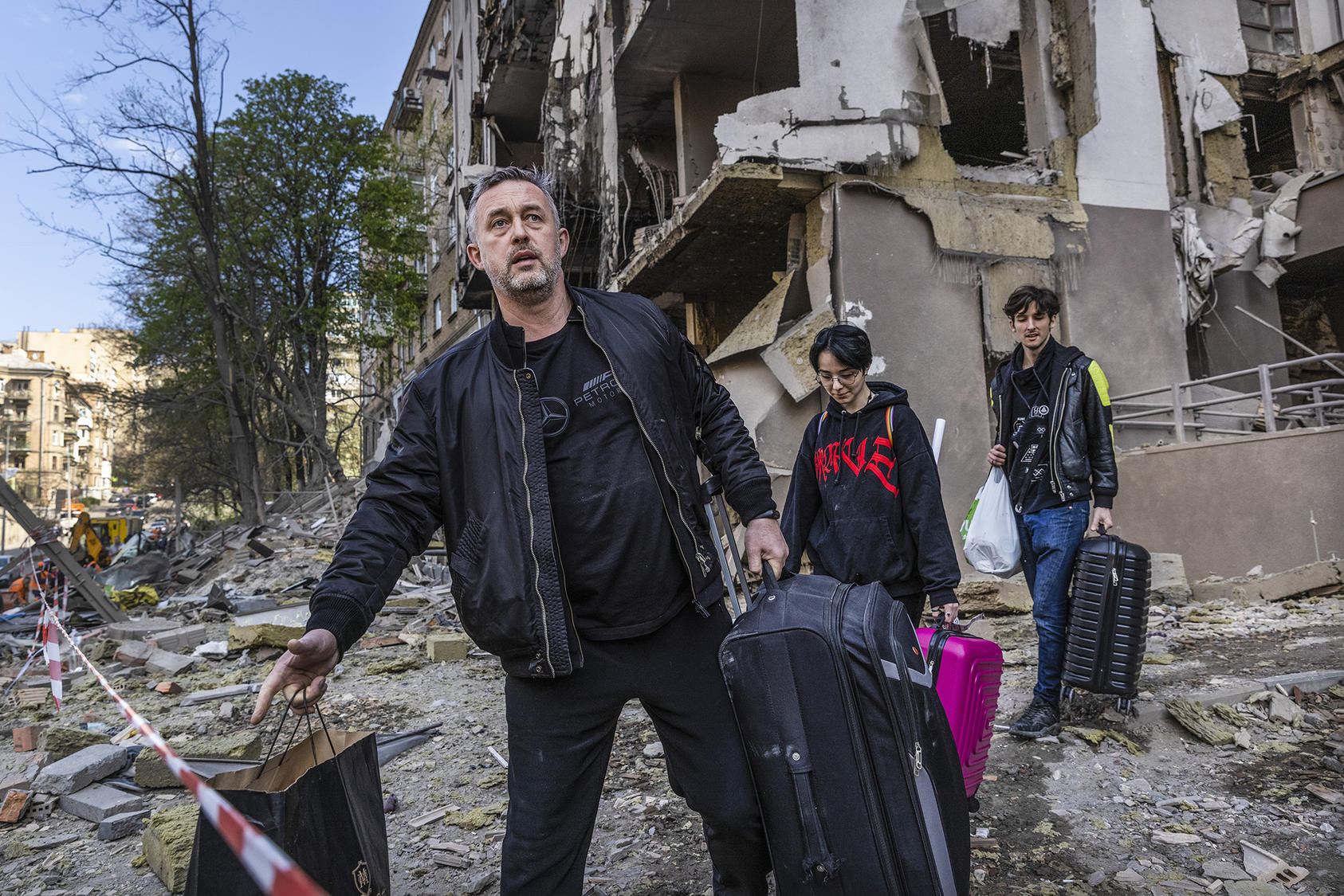 A Ukrainian family rescues belongings from their home, shattered by one of several Russian missiles that struck Kyiv as U.N. Secretary-General Antonio Guterres visited the city and held talks with the government. (David Guttenfelder/The New York Times)