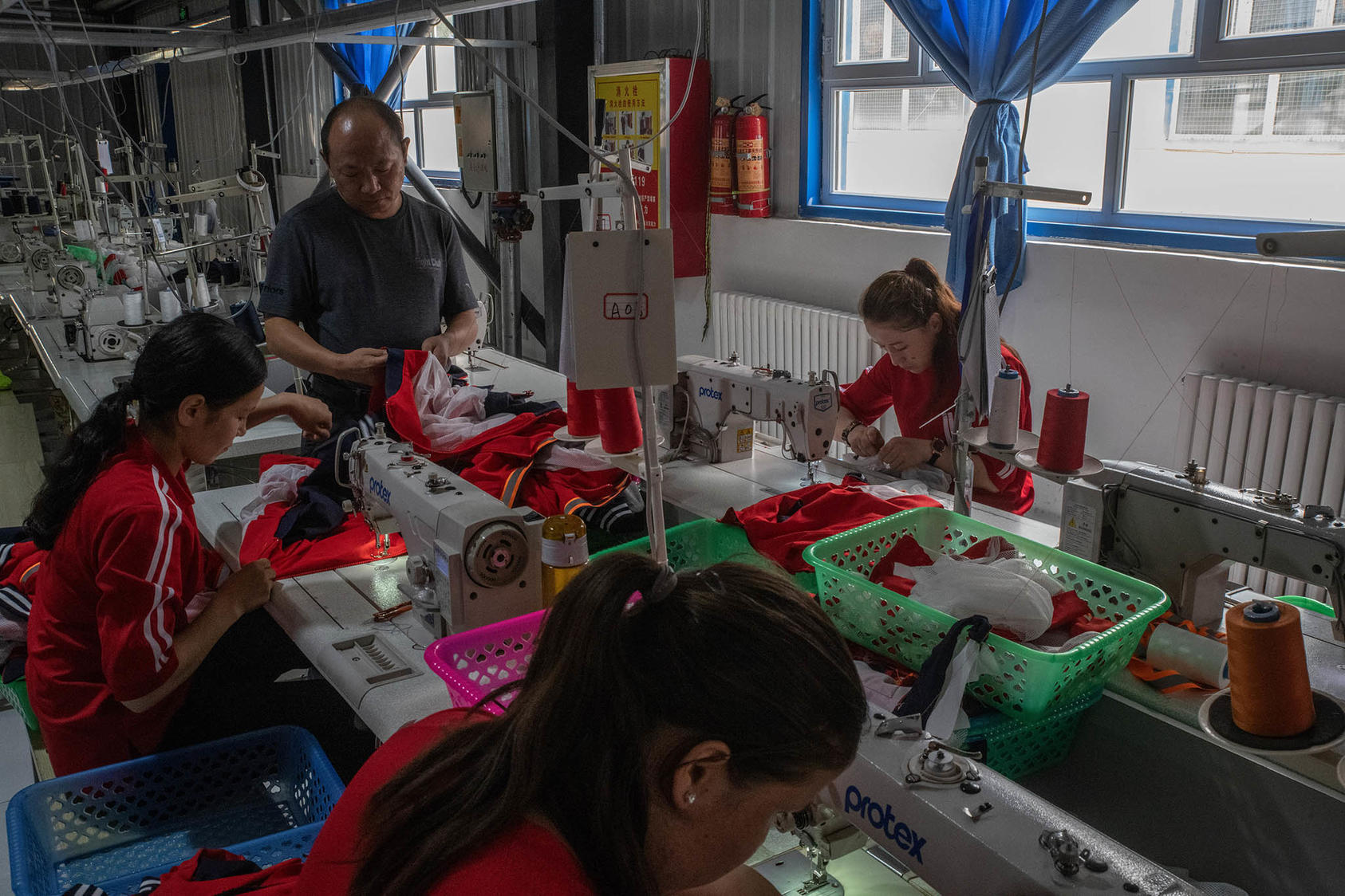 Uyghur workers at a factory in the Xinjiang region of China on Aug. 3, 2019. A wide range of products and raw materials flow from the region, where accusations of forced labor proliferate. (Gilles Sabrié/The New York Times)