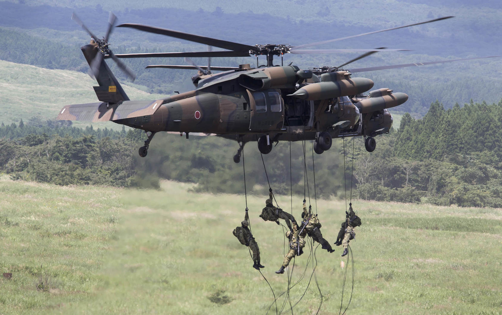 Members of Japan’s Self-Defense Forces rappel from a helicopter during live-fire drills in the foothills of Mount Fuji, in Gotemba, Japan, Aug. 27, 2017. (Tomohiro Ohsumi/The New York Times)