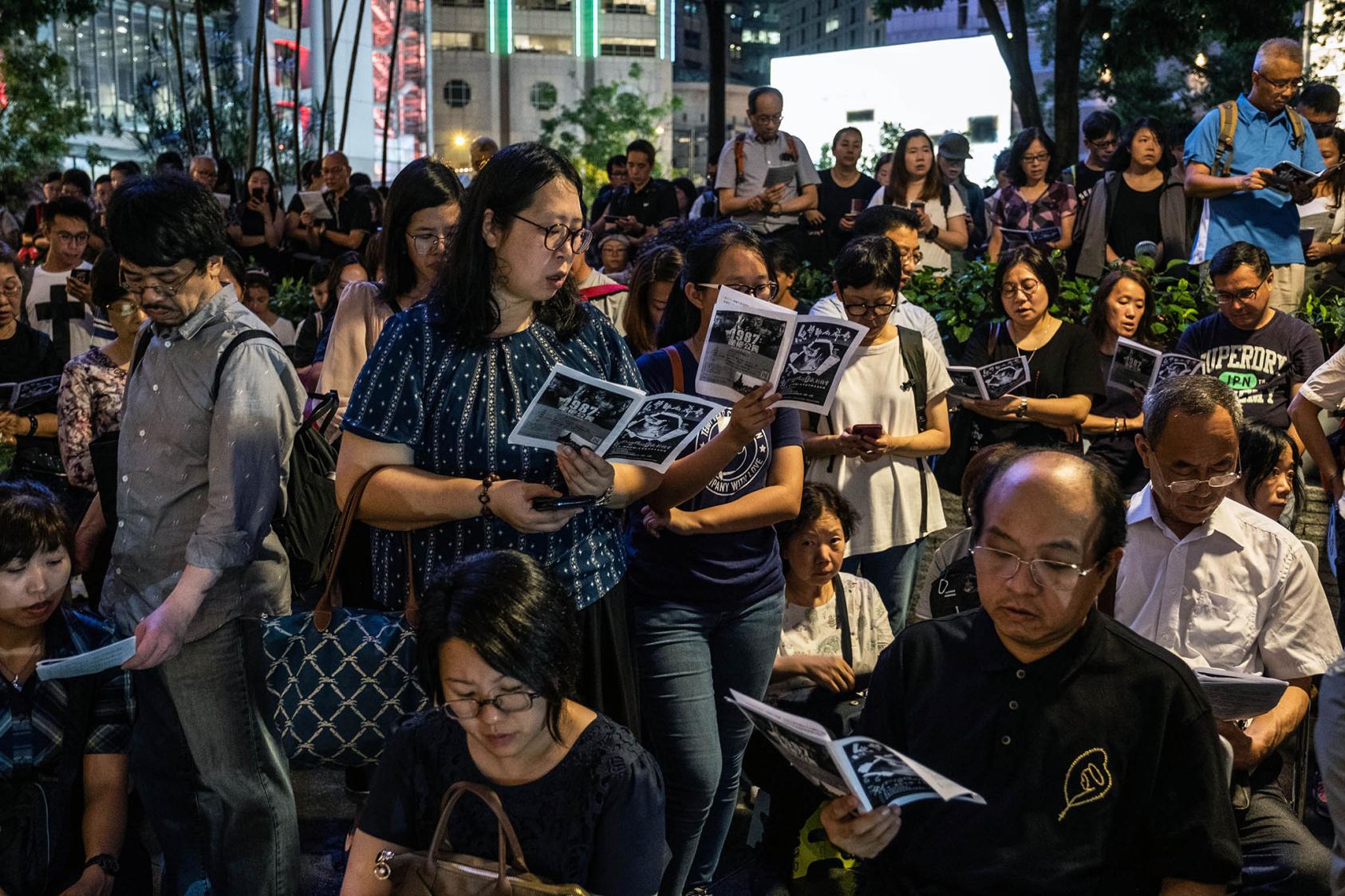 Protesters opposed to a proposed extradition law recite prayers outside the Court of Final Appeal in Hong Kong. June 18, 2019. (Lam Yik Fei/The New York Times)