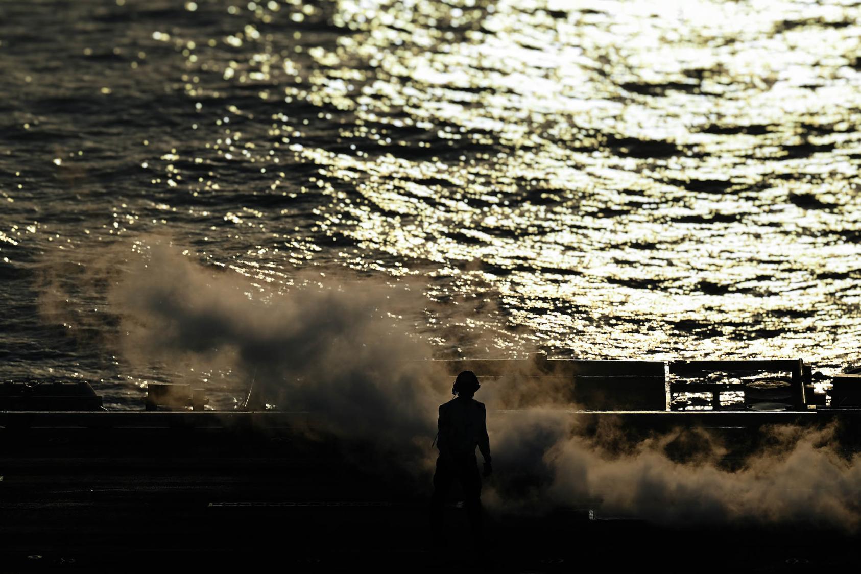 A U.S. Navy sailor walks on the flight deck of the aircraft carrier USS Dwight D. Eisenhower during operations against Houthi targets in the Red Sea, Feb. 20, 2024. (Kenny Holston/The New York Times)