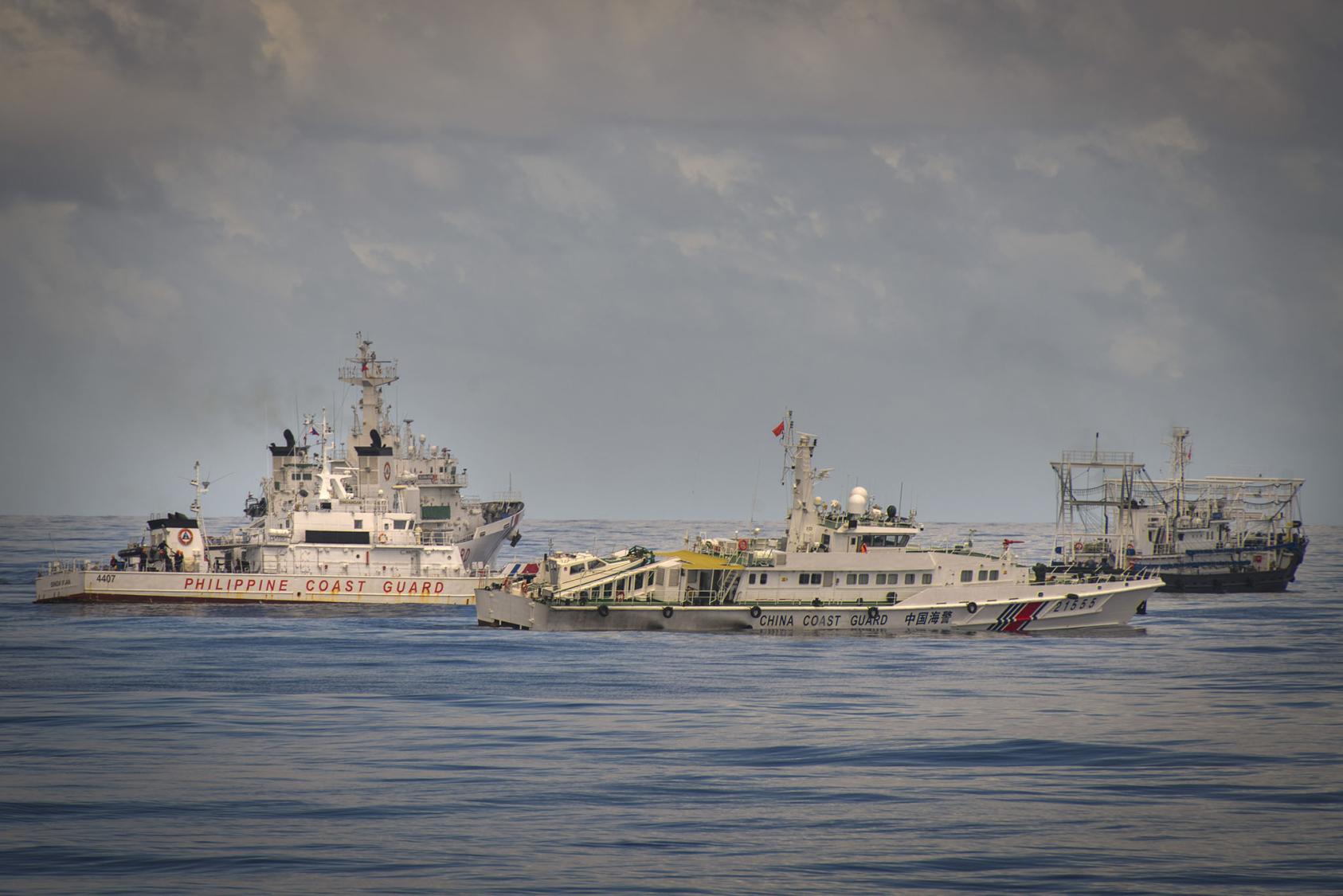 A Chinese Coast Guard and a Chinese militia vessel flank a Philippine Coast Guard ship on a mission to resupply the Sierra Madre, a manned Philippine outpost on Ayungin shoal in the South China Sea on Nov. 10, 2023. (Jes Aznar/The New York Times)