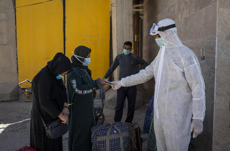 Iraqi border agents checking the passports of Iraqi citizens returning from Iran at the Zurbatiya border crossing, Monday, March 9, 2020. (Ivor Prickett/The New York Times)