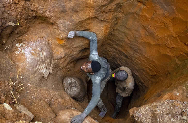 Jose Bumba, left, pulls a 220-pound bag of cobalt from a makeshift mine in Kasulo, the Democratic Republic of the Congo, on April 26, 2021. (Ashley Gilbertson/The New York Times)